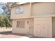 Beige two-story townhome with decorative front door and grated window at 5086 Mountain Vista St, Las Vegas, NV 89120