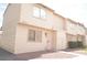 Beige two-story townhome with decorative front door and grated window at 5086 Mountain Vista St, Las Vegas, NV 89120