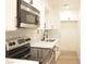 Modern kitchen with stainless steel appliances, white cabinets and stone backsplash at 5086 Mountain Vista St, Las Vegas, NV 89120