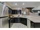 Updated kitchen with stainless steel fridge, dark cabinets, and open layout to the stairs at 5509 Ante Up Ct # 102, Las Vegas, NV 89122