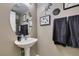 Stylish powder room features a pedestal sink, round mirror, and decorative wall art at 5509 Ante Up Ct # 102, Las Vegas, NV 89122