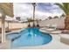 Relaxing backyard oasis with a sparkling pool, comfortable lounge chairs, and lush palm trees at 6 Megan Dr, Henderson, NV 89074