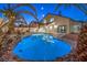 Stunning backyard with a rock-lined pool, lush greenery, and outdoor seating at 6 Megan Dr, Henderson, NV 89074