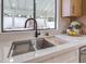 Close up of a stainless steel sink with a black faucet and white countertops at 6 Megan Dr, Henderson, NV 89074