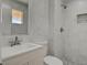 This bathroom features a tiled shower, hexagon tiling, and a sink with cabinet at 6225 Rassler Ave, Las Vegas, NV 89107