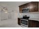 Modern kitchen featuring stainless steel appliances, dark wood cabinetry, and a herringbone backsplash at 6225 Rassler Ave, Las Vegas, NV 89107