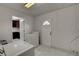 Bright laundry room featuring white tile flooring, washer and dryer with door to outside at 6225 Rassler Ave, Las Vegas, NV 89107