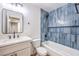 Charming bathroom features blue tile accent wall with shower/tub and updated vanity at 6308 Lawton Ave, Las Vegas, NV 89107