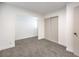 A spacious bedroom featuring gray carpet, a closet, and a door that leads to other areas at 6308 Lawton Ave, Las Vegas, NV 89107