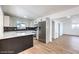 Modern kitchen features stainless steel appliances, white cabinetry, quartz countertops, and a stylish backsplash and wood flooring at 6308 Lawton Ave, Las Vegas, NV 89107