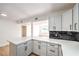 Updated kitchen featuring white cabinets, black backsplash and modern appliances at 6308 Lawton Ave, Las Vegas, NV 89107