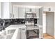 Updated kitchen features grey cabinets, stainless steel appliances, quartz counters, and black tile backsplash at 6308 Lawton Ave, Las Vegas, NV 89107