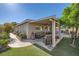 Lush backyard showing a covered patio with an outdoor lounge, water feature, and artificial grass at 7030 Silver Ridge Peak St, Las Vegas, NV 89166