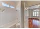 Bathroom featuring a combined shower and bathtub with tile walls and a window at 7540 Crystal Cave Dr, Las Vegas, NV 89117