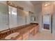 Spacious bathroom featuring double sinks with granite countertops and wood cabinets at 7540 Crystal Cave Dr, Las Vegas, NV 89117