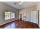 Bedroom featuring hardwood floors, a ceiling fan, and a bright window at 7540 Crystal Cave Dr, Las Vegas, NV 89117