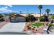 Charming single-story home with a three car garage, desert landscaping and palm trees under a blue sky at 7540 Crystal Cave Dr, Las Vegas, NV 89117