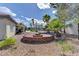 Backyard view with brick firepit and palm trees beyond, showcasing outdoor living space at 7540 Crystal Cave Dr, Las Vegas, NV 89117