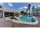 Backyard view showcasing the in-ground pool with surrounding rock detail, landscaping, and patio at 7540 Crystal Cave Dr, Las Vegas, NV 89117
