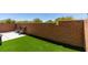 The backyard features artificial grass and a retaining wall for privacy at 8733 Autumn Teal Ave, Las Vegas, NV 89178