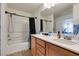 Bright bathroom featuring wood cabinets, marble countertops, and a shower with a blue curtain at 8733 Autumn Teal Ave, Las Vegas, NV 89178