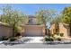 Inviting two-story home with a two-car garage and mature flowering trees in a well-maintained front yard at 8733 Autumn Teal Ave, Las Vegas, NV 89178