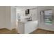 Bright kitchen featuring modern appliances, white cabinets, a stylish black range hood, and hardwood flooring at 9512 Quail Ridge Dr, Las Vegas, NV 89134