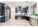 A modern kitchen featuring stainless steel appliances, black cabinetry, and light wood-look flooring at 965 Nevada State Dr # 15104, Henderson, NV 89002