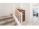 Carpeted staircase with white railings, complemented by a stylish display case and light wood floors at 965 Nevada State Dr # 15104, Henderson, NV 89002