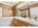 Staged bathroom featuring a double sink vanity, large mirror, soaking tub and decorative lighting at 9688 Meeks Bay Ave, Las Vegas, NV 89148