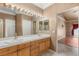 Bathroom featuring a double sink vanity, large mirror, decorative lighting, and tile flooring at 9688 Meeks Bay Ave, Las Vegas, NV 89148