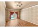 A bedroom featuring tiled walls, wood floor, ceiling fan, and access to the backyard pool at 9688 Meeks Bay Ave, Las Vegas, NV 89148
