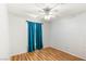 Bedroom with a ceiling fan, blue curtain and hardwood floors with accent wall at 9688 Meeks Bay Ave, Las Vegas, NV 89148
