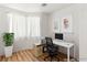 Staged office space with a desk, chair, and a plant near a large window allowing natural light at 9688 Meeks Bay Ave, Las Vegas, NV 89148