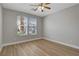 Neutral bedroom features a ceiling fan, light hardwood floors and two windows for lots of natural light at 981 Buffalo River Ave, Henderson, NV 89002