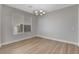 Bright dining room featuring wood floors, neutral walls, and a modern chandelier at 981 Buffalo River Ave, Henderson, NV 89002