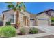 Beige single story home with a three car garage, landscaped yard, and palm tree under a clear, blue sky at 981 Buffalo River Ave, Henderson, NV 89002