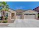 Beige single story home with a three car garage, landscaped yard, and palm tree under a clear, blue sky at 981 Buffalo River Ave, Henderson, NV 89002