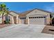 Beige single story home with a three car garage, landscaped yard, and palm tree under a clear, blue sky at 981 Buffalo River Ave, Henderson, NV 89002