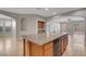 Open kitchen featuring granite countertops, wood cabinets, a center island, and an adjacent living area at 981 Buffalo River Ave, Henderson, NV 89002