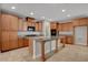 A kitchen is shown with wooden cabinets, granite counters, a center island, and stainless steel appliances at 981 Buffalo River Ave, Henderson, NV 89002