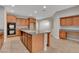 A kitchen is shown with wooden cabinets, granite counters, a center island, and stainless steel appliances at 981 Buffalo River Ave, Henderson, NV 89002