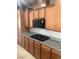 A kitchen featuring wooden cabinets, a black microwave, and a cooktop set against a granite countertop at 981 Buffalo River Ave, Henderson, NV 89002