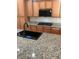 A kitchen showcasing wooden cabinets and sleek black appliances, including a built-in microwave and a cooktop at 981 Buffalo River Ave, Henderson, NV 89002