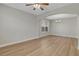 Open-concept living room featuring light hardwood floors, neutral walls, a ceiling fan and decorative archways at 981 Buffalo River Ave, Henderson, NV 89002