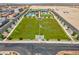 Community lawn and green space with a US flag, a shelter, playground, and pool with homes beyond at 10049 Cardinal Knoll Ave, Las Vegas, NV 89143