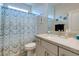 Bathroom with a shower and tub enclosed by a blue and white curtain, large mirror and light grey vanity at 10049 Cardinal Knoll Ave, Las Vegas, NV 89143