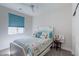 Bright bedroom with a ceiling fan, window with blue shade and a beach themed bed set at 10049 Cardinal Knoll Ave, Las Vegas, NV 89143