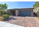 Attractive single-story home featuring a paved driveway, two-car garage, and a welcoming covered entryway at 10049 Cardinal Knoll Ave, Las Vegas, NV 89143