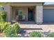Close-up of a cozy front porch with seating, a decorative stone accent wall, and a stylish front door at 10049 Cardinal Knoll Ave, Las Vegas, NV 89143
